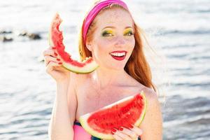 Smiling girl with freckles holding watermelon