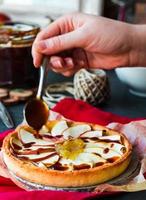 apple tart with pear jam pour caramel, hands