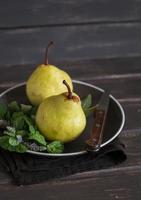 fresh pears and mint on a brown plate