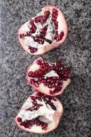 broken pomegranate on a marble top photo