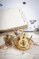 engranajes de reloj mecánico en la vieja mesa de madera foto