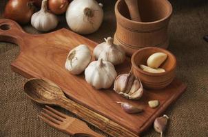 Garlic on cutting board , close-up on sacking. burlap background photo