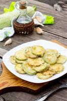 Fried zucchini with garlic in a bowl on a table photo