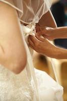 Bride when tightening the dress photo
