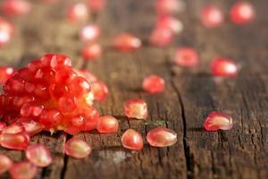 Pomegranate seeds vibrant on a wooden table photo