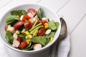 spinach salad with cherry tomatoes and corn in bowl photo
