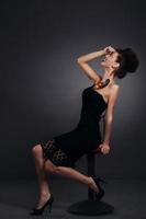 Woman with snail in black dress laughing. Fashion. Gothic photo