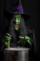 Scary witch stirring a smoky cauldron