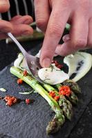chef preparing asparagus with poached quial eggs