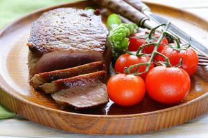 grilled meat beef steak with vegetable garnish (asparagus and tomatoes) photo