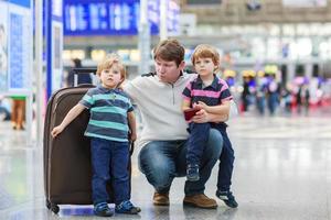 Father and two little sibling boys at the airport photo