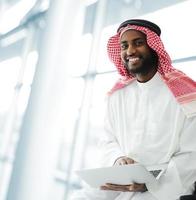 Hombre de negocios árabe con tableta en la oficina