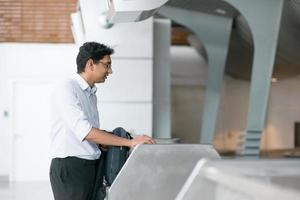 Hombre indio en el mostrador de facturación del aeropuerto foto