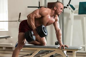 Healthy Man Doing Back Exercises With Dumbbell photo