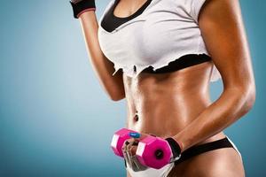 Torso shot of muscular woman with dumbbells