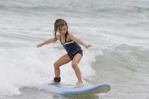 Young girl surfing on surfboard photo