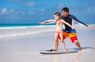 Father and daughter practicing surfing photo