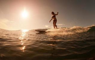 The girl with surf at sunrise