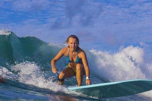 chica surfista en increíble ola azul foto
