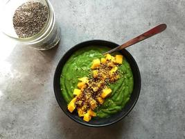 Green smoothie bowl with chopped mango and chia seeds photo