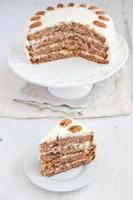 Piece of Hummingbird cake with pecans and cream cheese frosting photo