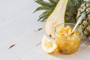 mermelada de piña en frasco de vidrio con cuchara, limón, pera