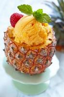 Fruit sorbet ice cream in small pineapple photo