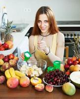 mujer de pelo largo positiva cocinar ensalada de frutas