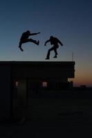 Two men doing martial arts on roof photo