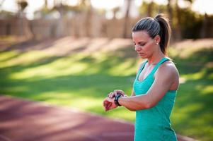 imagen de una atleta femenina ajustando su monitor de frecuencia cardíaca foto
