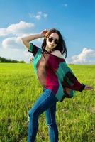 Young beatiful girl with long dark hair in green field photo