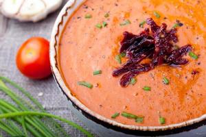 Tomato soup with sun dried tomatoes. Wooden background