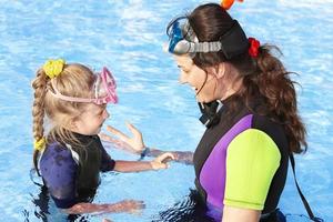 Child with mother in swimming pool . photo