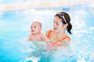 madre y su bebé recién nacido divirtiéndose en la piscina foto