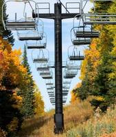 Empty ski lift chairs and fall foliage