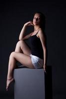 Image of sporty young girl posing sitting on cube photo