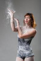 Beautiful expressive ballet dancer posing with flour at studio