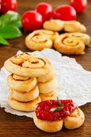 Puff pastry "ears" with sun-dried tomatoes and rosemary.