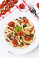 pasta with sausage, tomatoes and olives, top view photo