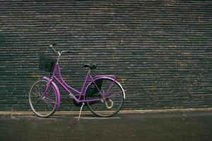 Bicicleta clásica vintage hipster púrpura en la calle foto