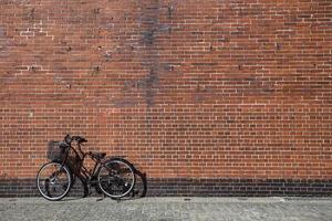 Bicycle is attached with brick background photo