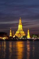Wat Arun a través del río Chao Phraya durante la noche foto