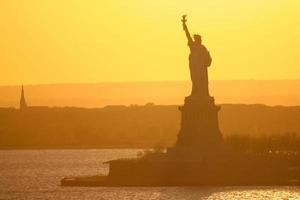 estatua de la libertad en la ciudad de nueva york al atardecer foto