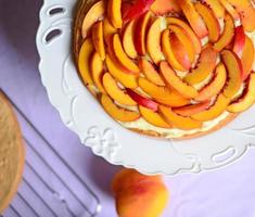 Fresh peach cake on table photo