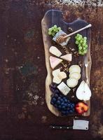 set de aperitivos de vino: selección de queso francés, panal, uvas, durazno y foto