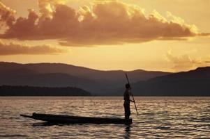 hombre remando en una canoa tradicional foto