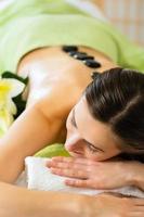 mujer teniendo bienestar masaje con piedras calientes foto