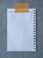 Sheet from notebook paper on grey cement board background photo