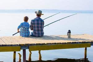 boy and his father fishing togethe photo
