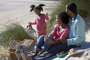 familia sentada en la playa foto